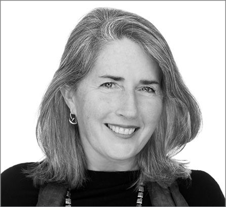 Susan Rodriguez; Black and white portrait of a smiling woman with shoulder-length hair, wearing a dark top. She exudes a warm, approachable demeanor.